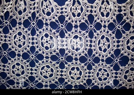 Crocheted openwork napkin on a blue background. Stock Photo