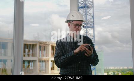 Engineer using mobile phone in helmet. Stock Photo