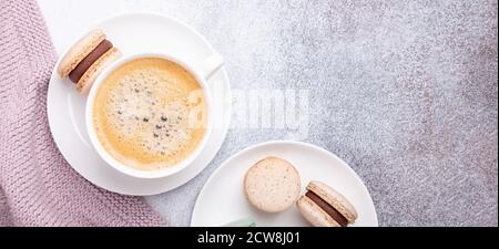 Horizontal banner with wool plaid, coffee and macarons on stone background. Cozy autumn composition. Flat lay, top view - Image Stock Photo