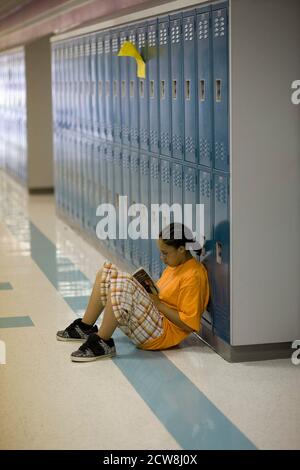 Pflugerville, Texas: May 30, 2008: Seventh grade student sits in the hallway reading at Park Crest Middle School, a large suburban campus near Austin with 1,000 students. ©Bob Daemmrich Stock Photo