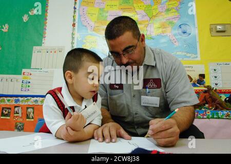 A San Antonio, Texas, program at at Head Start pre-school provides a free dinner and family time for young children and their parents. After dinner, adults meet for a group counseling session on successful parenting techniques, then rejoin their kids to read and write together.   ©Bob Daemmrich Stock Photo