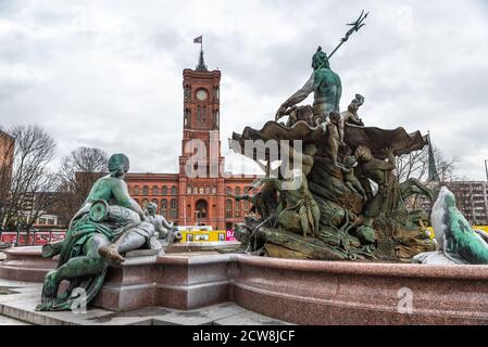 Teal Neptune Fountain with the Red City Hall of Berlin in the background on a winter day, Germany Stock Photo