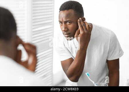 African American Man Having Hair Loss Problem Standing In Bathroom Stock Photo