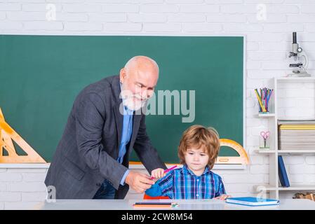 Learning and education concept. Teachers day. Teacher is skilled leader. Friendly bearded man with old mature teacher in classroom. Grandfather and Stock Photo