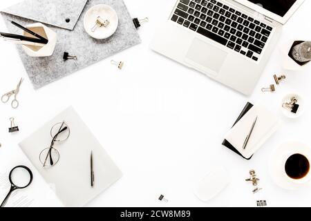 Home office workspace frame with laptop, clipboard, notebook and accessories on white background. Flat lay, top view Stock Photo