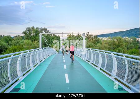 Bicycle riders riding on bicycle bridge (called “Freedom bridge”) connecting two countries Slovakia and Austria (Bratislava, SLOVAKIA) Stock Photo