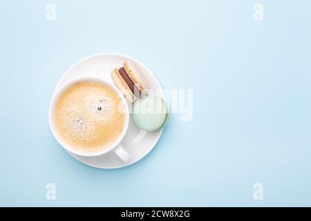 Creative flat lay. Cup of coffee, various macarons on blue background. Copy space for your text - Image Stock Photo