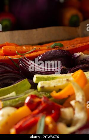 Stewed vegetables on a baking sheet, carrots with garlic and red onions,zucchini with bell pepper and beetroot, sweet and hot peppers and spices Stock Photo