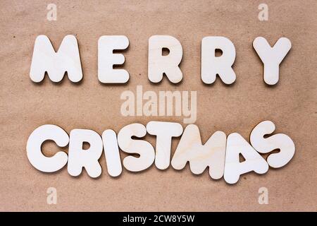 Merry Christmas text on craft paper background made of wooden alphabet Stock Photo