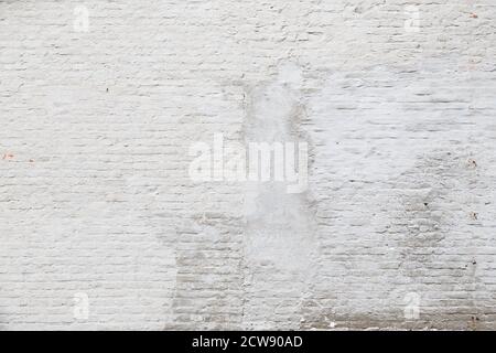 Aged and weathered brick wall, plastered and painted in white. Front view. High resolution full frame textured background. Copy space. Stock Photo