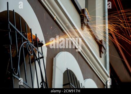 Welder used grinding stone on steel in manufacturing with sparks Stock Photo