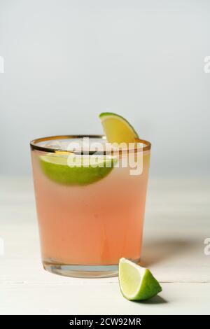 Paloma cocktail served with grapefruit and lime slices. White wooden background, high resolution Stock Photo