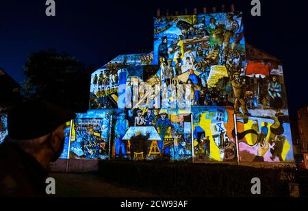 Leith, Edinburgh, Scotland, United Kingdom, 28th September 2020. Leith Lights Up: a Double Take Production lighting projection onto a local mural depicting Leith's social and industrial history by artists Tim Chalk and Paul Grime installed in 1986. The event runs until October 4th Stock Photo