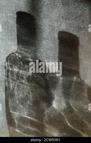 Milan - 09/26/2020 : shadow of bottles with reflection on a dark grunge background Stock Photo