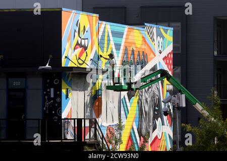 Durham, North Carolina, USA. 28th Sep, 2020. Artist GREG MIKE of Atlanta, GA works on his mural at Ã”UHill Walls,Ã a dense, walkable art experience with over 40,000 square feet of murals on 15 contiguous acres in Durham, North Carolina.In September, forty two local, national and international artists will create one of the largest consolidated collections of murals in the Southeastern US.Ã”UHill WallsÃ will be the driving force behind University Hill, a mixed-use redevelopment of an abandoned strip center with award winning food, drink, wellness and residential living. (Credit Image: © Stock Photo