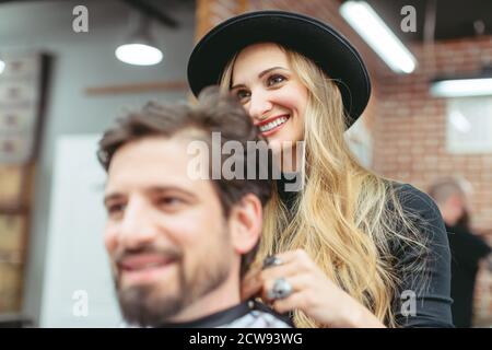 Man consulting woman hair stylist for advise on cut and styling Stock Photo