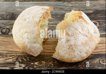 Broken round loaf of bread on table as symbol of consecrated bread for communion Stock Photo