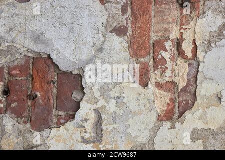 destroyed brick wall with fallen off plaster. Stock Photo