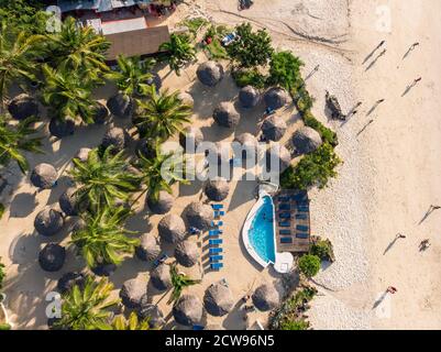 Top Aerial view of Thatched roofed beach umbrellas of luxury ocean view resort at the beautiful white sand ocean coast in Nungwi at Zanzibar island Stock Photo