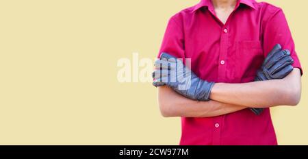 Cropped image of mechanic in uniform with cross arms, isolated in yellow backgrounds Stock Photo