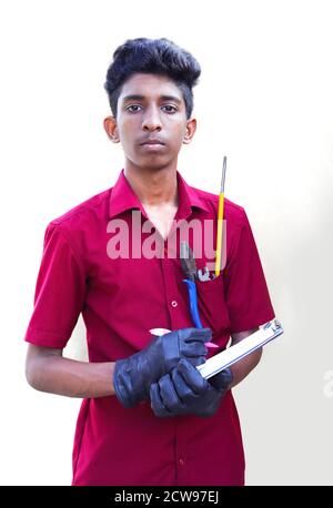 young mechanic writing on a clipboard on a white and gray backgrounds Stock Photo