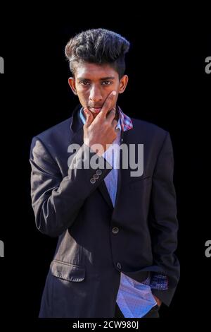 Handsome young man on black background looking at camera. Portrait of laughing young man Stock Photo