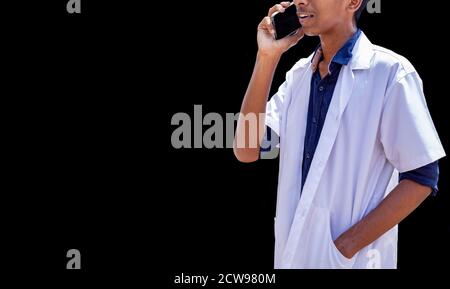 Cropped shot of male doctor speaking on the smart phone, standing isolated over black backgrounds Stock Photo