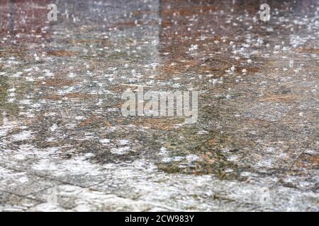 Abstract drawing of falling rain on the granite site of the city sidewalk. Stock Photo