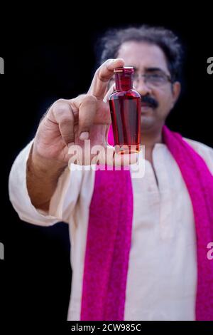 Senior man holding something with hand showing at camera Stock Photo