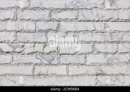 Wall background and texture of gray marble tiles with chips around the perimeter and brown veins on the surface, close-up. Stock Photo
