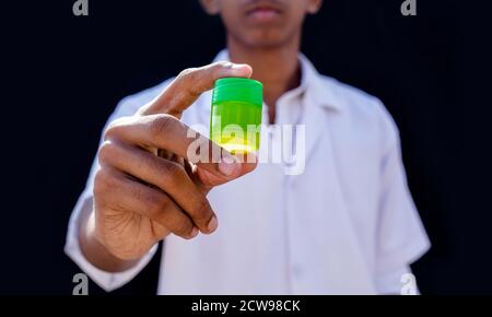 Young doctor holding green bottle of prescription pill Stock Photo