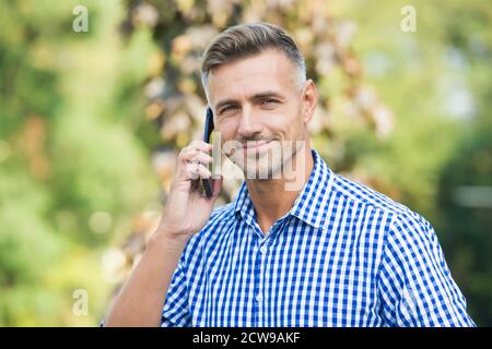 mature guy is always online. agile business concept. communication with modern devices. cheerful man speak on mobile phone. handsome businessman has groomed graying hair. Stock Photo