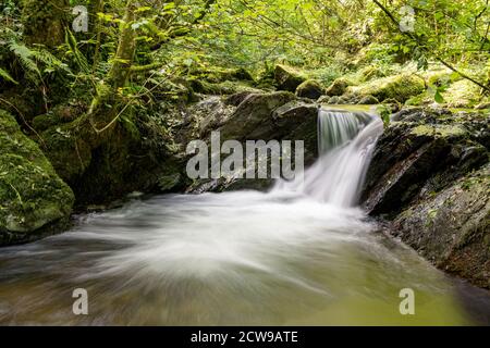 Long exposure of a waterfall on the Hoar Oak Water river at Watersmeet in Exmoor National Park Stock Photo