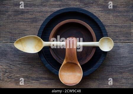 Top view two cute little wooden spoons inside of two cup holders on wooden table, eco friendly cutlery concept, selective focus Stock Photo