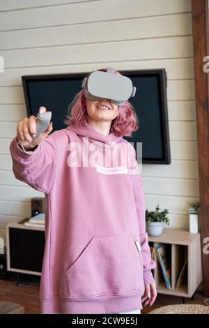 Young woman gamer wear vr glasses hold controller experience virtual reality. Stock Photo
