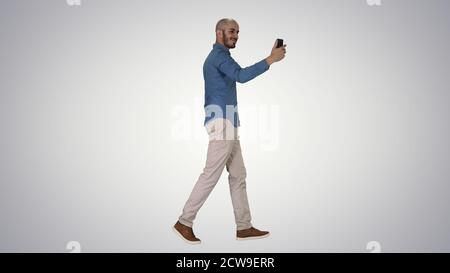Happy smiling handsome young man making selfie while walking on Stock Photo