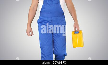 Construction worker in hard hat holding plastic canister and wal Stock Photo