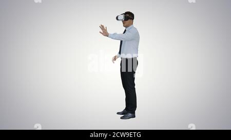 Businessman in virtual reality headset walking in virtual world Stock Photo