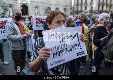 A Catalan pro-independence protester wearing a protective mask is seen displaying a placard that says 'we defend the president, we fight for independence' during the protest.The Superior Court of Justice of Catalonia condemned the president of Catalonia, Quim Torra, with disqualification, for refusing to remove a banner in favor of Catalan political prisoners as ordered by the Central Electoral Board. Stock Photo