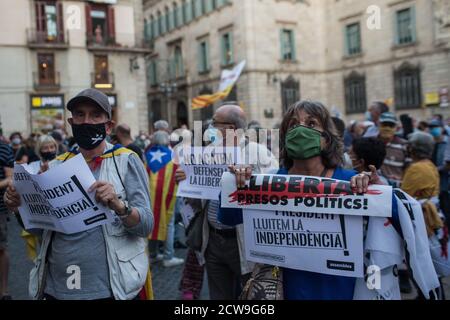 A couple of supporters of the president of Catalonia, Quim Torra, are seen wearing facemasks while displaying banners reading 'freedom, political prisoners' and 'we fight for independence' during the protest.The Superior Court of Justice of Catalonia condemned the president of Catalonia, Quim Torra, with disqualification, for refusing to remove a banner in favor of Catalan political prisoners as ordered by the Central Electoral Board. Stock Photo