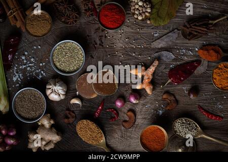 Condiment of indian food Spice garnish background on wood table top view. Seasoning of Asian organic herb cuisine flavour in kitchen board, chilli. Stock Photo