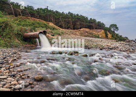 Dirty sewage from a factory pipe, chemical pollution of environment Stock Photo