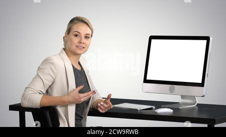 Young pretty lady talking to the camera and showing something on Stock Photo