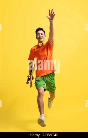 Holding a skateboard bouncing young man Stock Photo