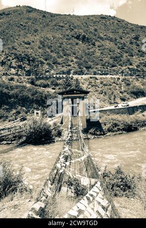 Iron chain suspension bridge next to Tachogang Lhakhang in Paro, Bhutan Stock Photo