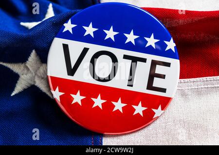 A red, white and blue VOTE button on an American flag Stock Photo