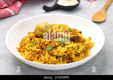 Chicken Biryani, Chicken Pulav. Garnished with fried onion & coriander. Biryani served with raita is a famous Spicy nonvegetarian rice dish of India. Stock Photo