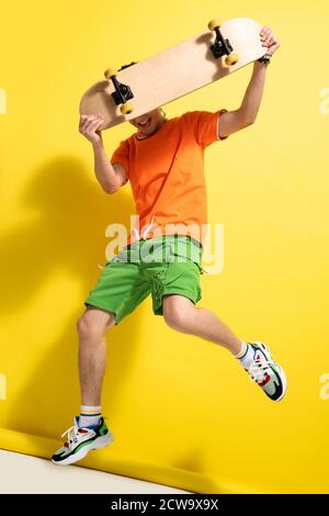 Holding the skateboard bouncing young man Stock Photo