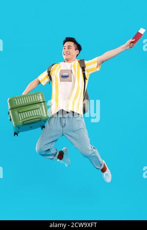 Carrying a suitcase bouncing young man Stock Photo