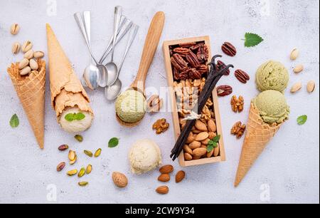 Pistachio and vanilla ice cream in bowl  with mixed nuts setup on white stone background . Summer and Sweet menu concept. Stock Photo